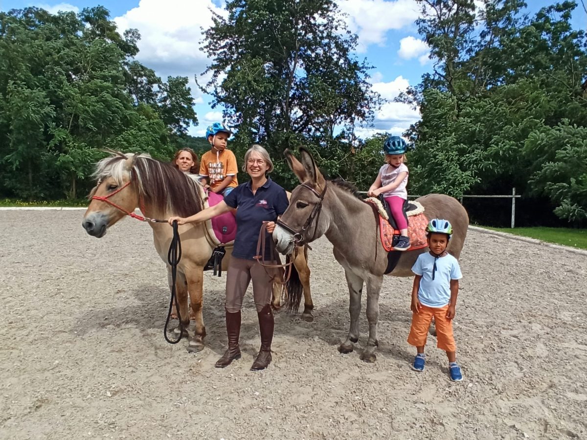 Kindergruppe mit Mutter ,Norweger Pferd und Therapieesel daneben Kirsten Rickes vom Reitverein